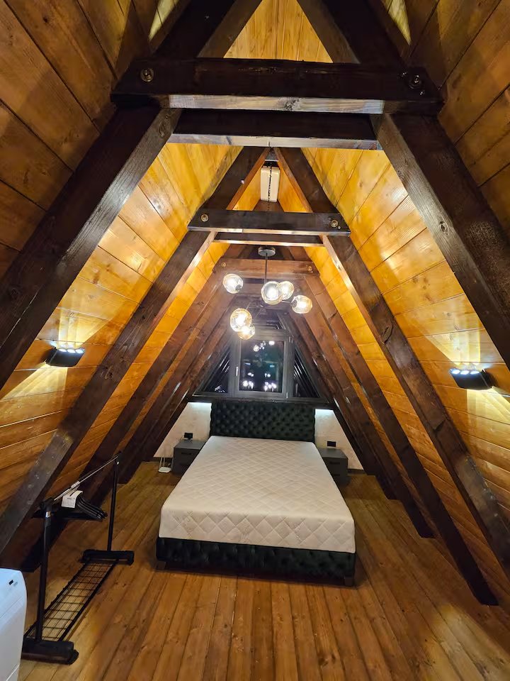 Bedroom loft view with dramatic A-frame ceiling