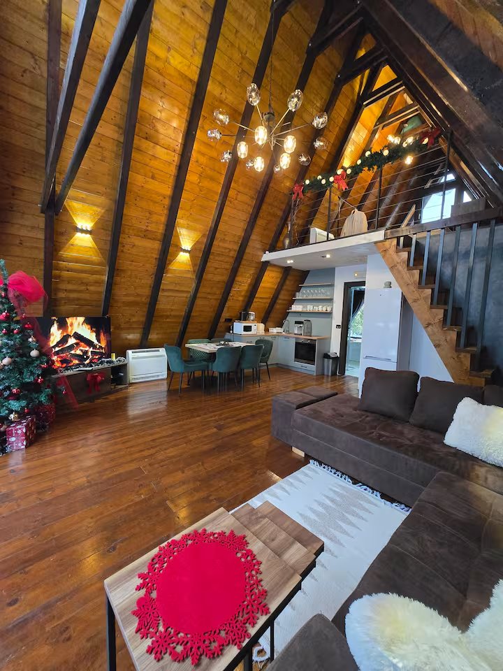 A-frame interior chandelier glowing in the evening
