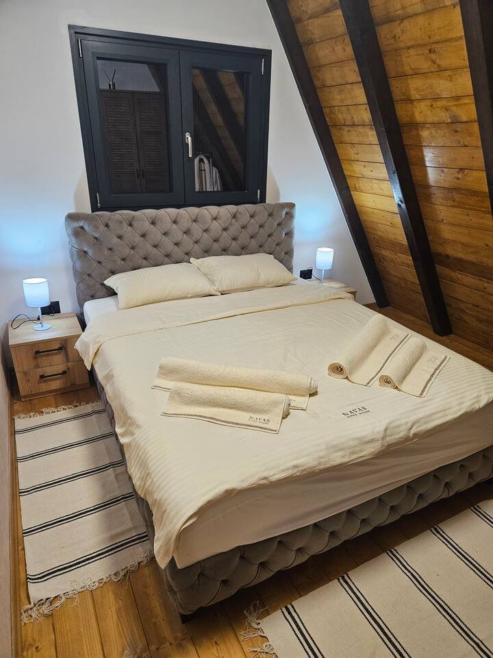 Master bedroom with warm lighting and wooden ceiling