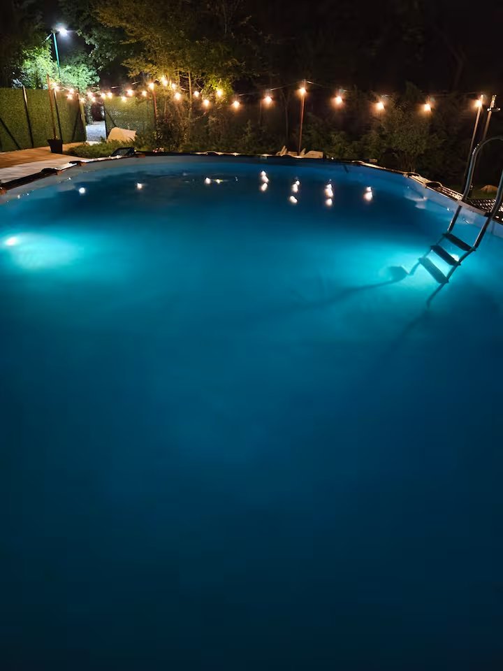 Swimming pool with vibrant turquoise illumination at night